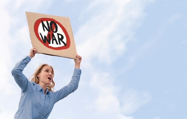 Free photo young person holding anti war protest sign