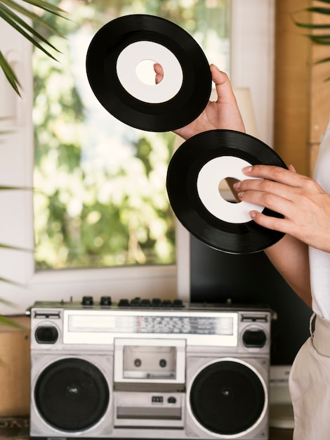 Young person holding vintage vinyl records indoors