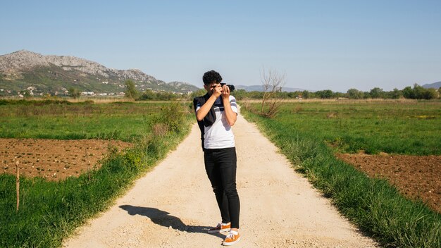 야외에서 촬영하는 젊은 사진 작가
