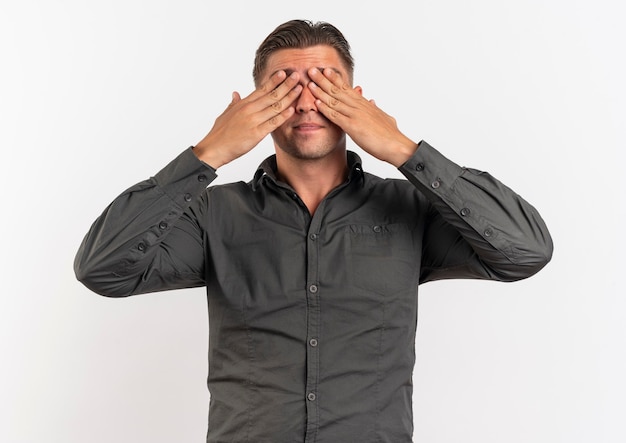 Young pleased blonde handsome man closes his eyes with hands isolated on white background with copy space