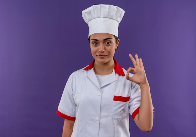 요리사 유니폼 제스처 확인 손 기호 복사 공간 보라색 벽에 고립 된 젊은 기쁘게 백인 요리사 소녀