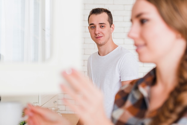 Young pleased couple in kitchen at home