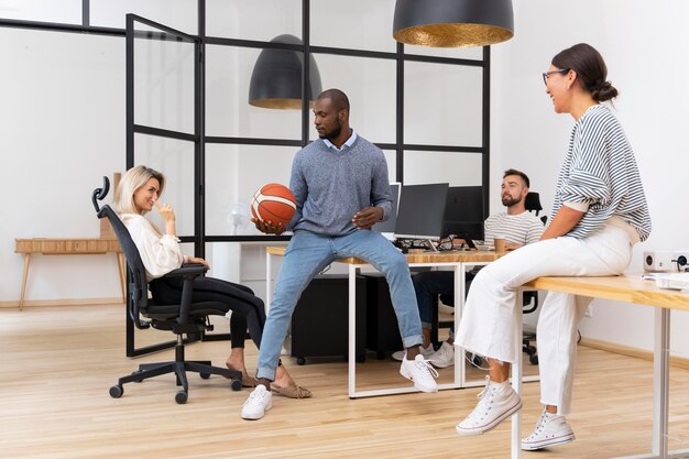 Young pleople playing with ball in office