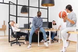 Free photo young pleople playing with ball in office