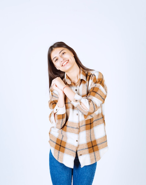 Foto gratuita giovane donna positiva in piedi sul muro bianco.