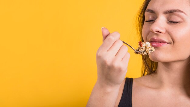 Young positive woman with spoon of flakes