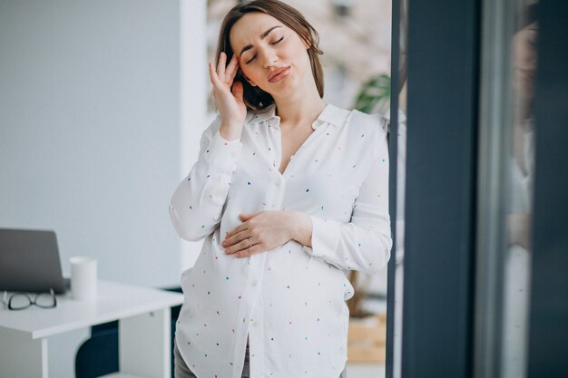 Young pregnant business woman at the office