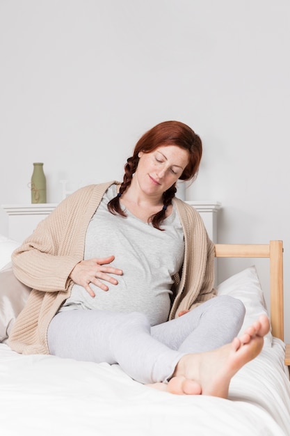 Young pregnant woman in bed