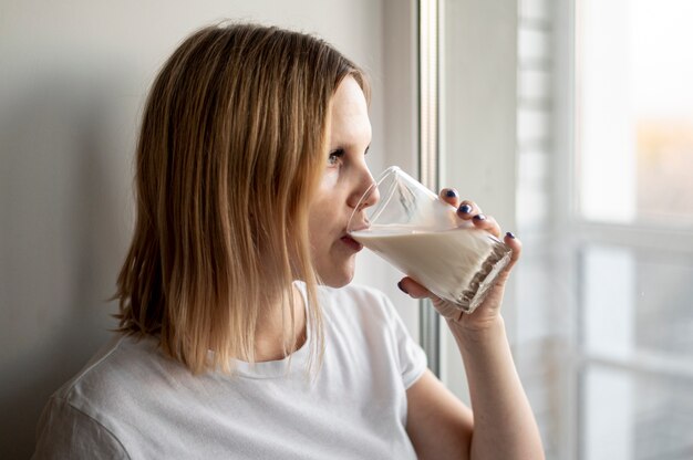 Молодая беременная женщина пьет молоко