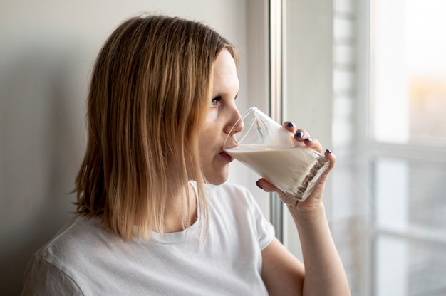 Молодая беременная женщина пьет молоко