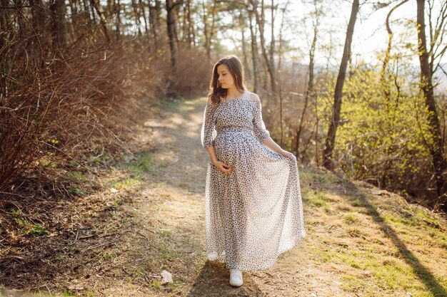 屋外の公園でリラックスした若い妊娠中の女性