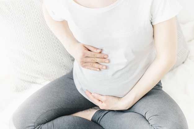 Giovane donna incinta che tocca la sua pancia