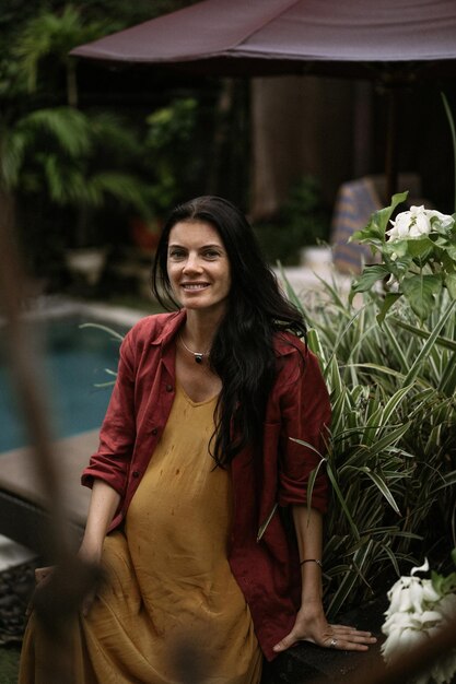 Young pregnant woman with long dark hair in a tropical location