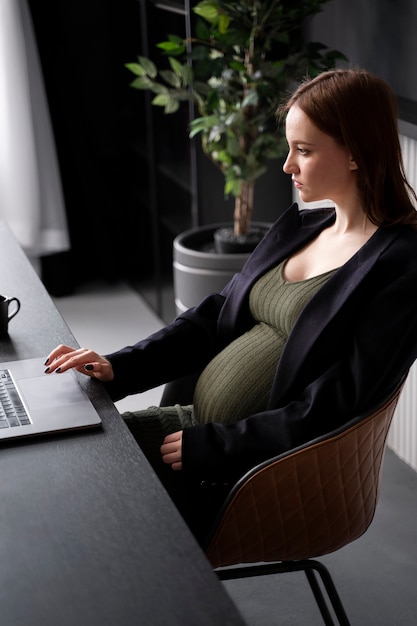 Молодая беременная женщина на работе