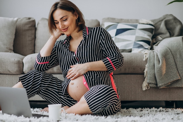 Foto gratuita giovane donna incinta che lavora al computer a casa