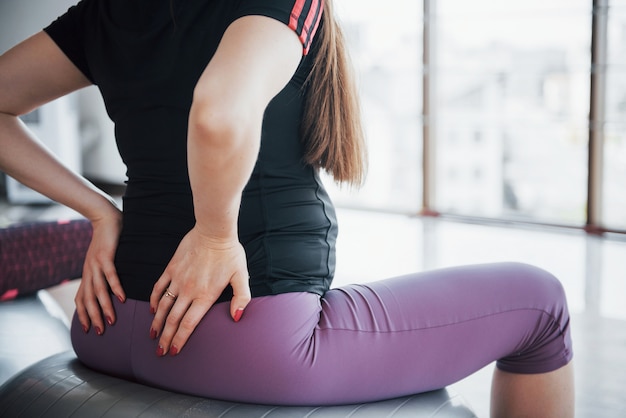 Giovani donne incinte che si siedono sulla palla per gli esercizi in palestra