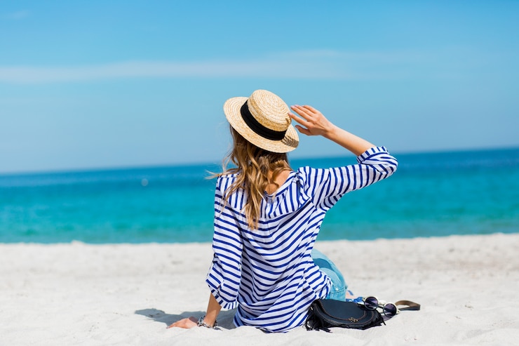 Free Photo young pretty blonde tanned young woman standing on the beach near the sea back waiting and dreaming about