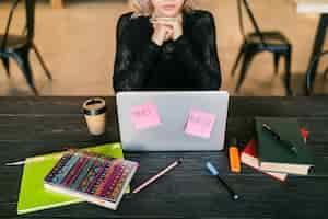 Free photo young pretty busy woman working on laptop, busy paper stickers, consentration, student in class room, top view on table with stationery, do not disturb