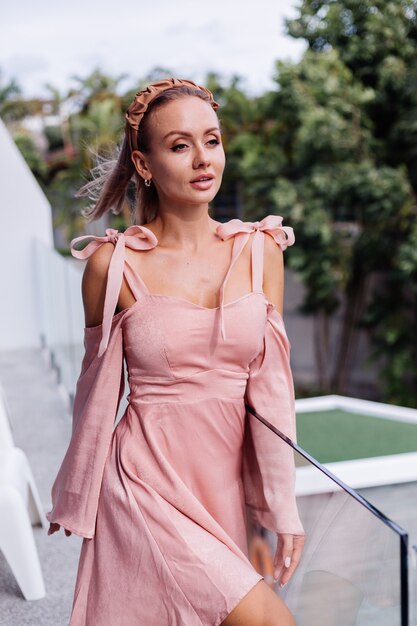 Young pretty caucasian woman alone in summer cute dress on vacation at luxury villa