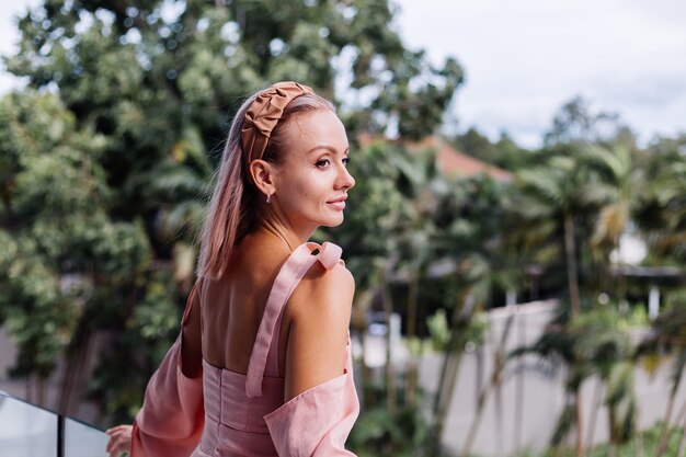 Young pretty caucasian woman alone in summer cute dress on vacation at luxury villa