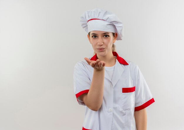 Young pretty cook in chef uniform sending blow kiss  
