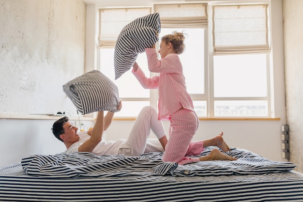 Free photo young pretty couple having fun on bed in morning stay together at home alone