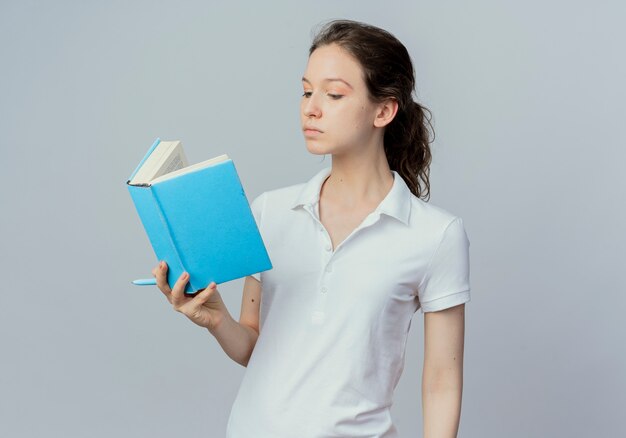 젊은 예쁜 여자 학생 보유 및 복사 공간 흰색 배경에 고립 손에 펜으로 책을 읽고