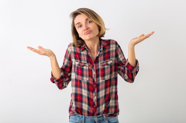 Young pretty funny emotional woman in checkered shirt posing isolated on white studio wall, showing gesture