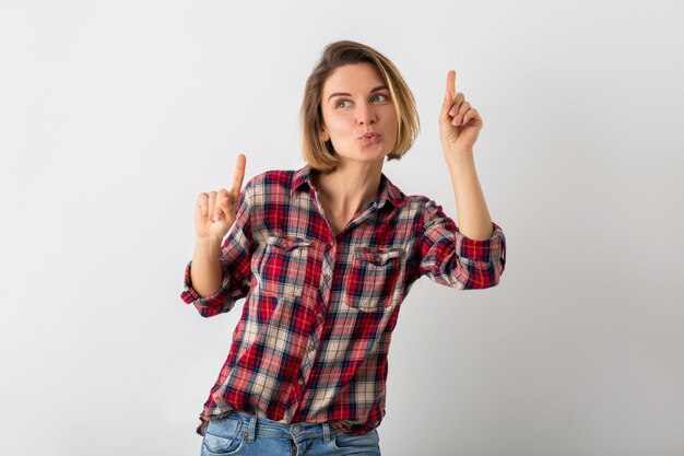 Young pretty funny emotional woman in checkered shirt posing isolated on white studio wall, showing gesture