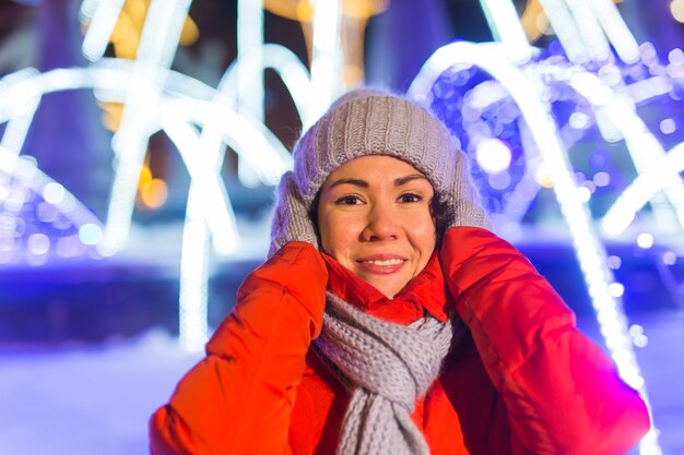 Молодая довольно забавная девушка веселится на открытом воздухе в зимнем рождественском городе и концепции зимних праздников