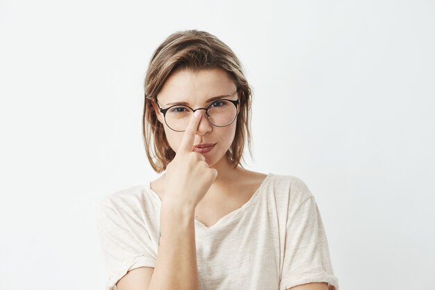 Young pretty girl correcting glasses .