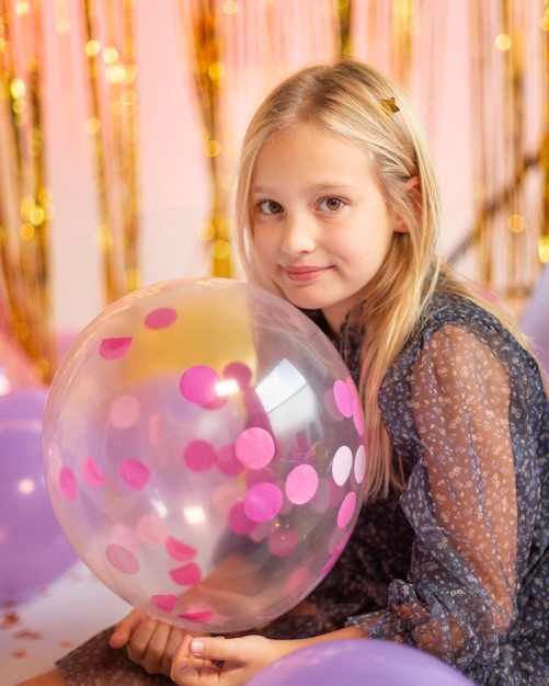 Young pretty girl at festive party with balloons