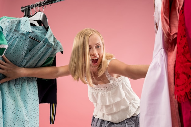 Foto gratuita la giovane ragazza carina guarda i vestiti e prova mentre sceglie al negozio