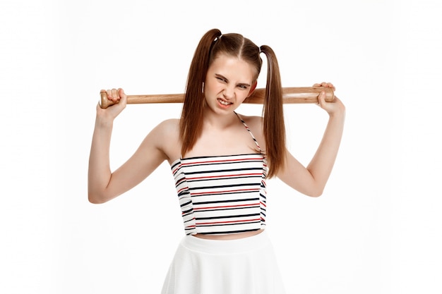 Young pretty girl posing with bat, isolated on white wall