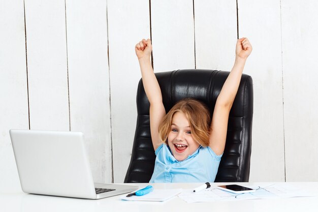 Free photo young pretty girl sitting at working place, rejoicing in office.