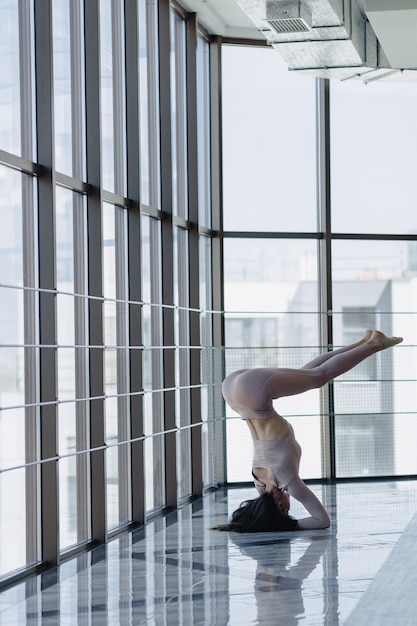 Young pretty girl in sportswear by the window