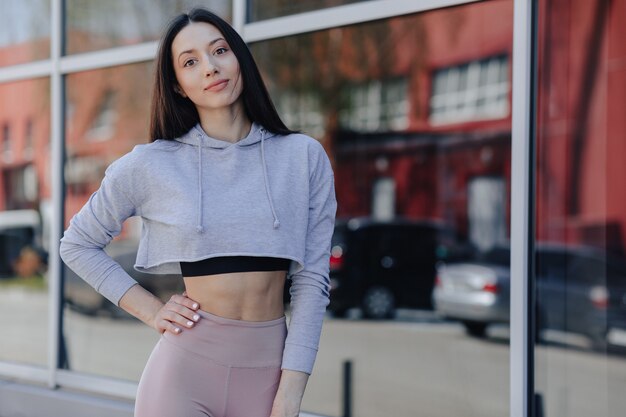 Young pretty girl in sportswear by the window