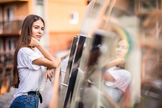 Giovane ragazza graziosa che sta sul ponte all'aperto