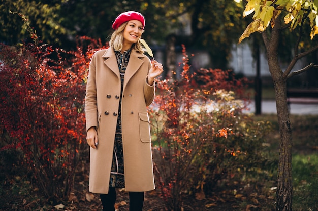 Free photo young pretty lady in a red barret outside in park