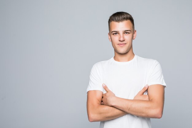 Young pretty man in a white T-shirt isolated on white hold arms crossed