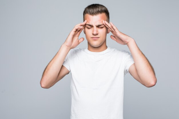 Young pretty man in a white T-shirt isolated on white is thinking, pain concept