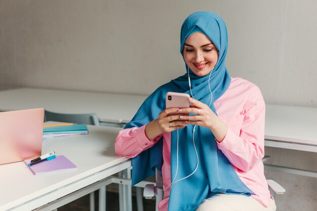 사무실 방, 온라인 교육에서 노트북에서 일하는 hijab에 젊은 꽤 현대 무슬림 여성