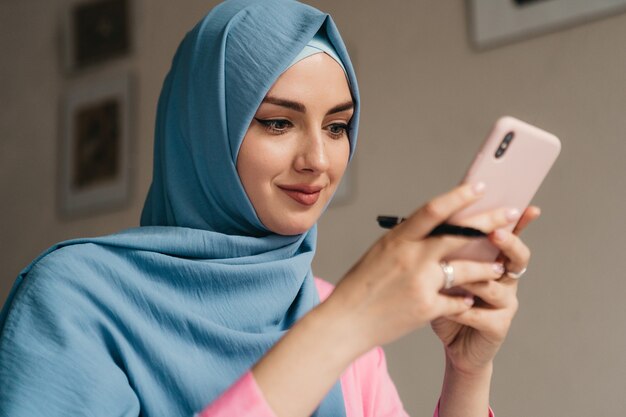 사무실 방, 온라인 교육에서 노트북에서 일하는 hijab에 젊은 꽤 현대 무슬림 여성