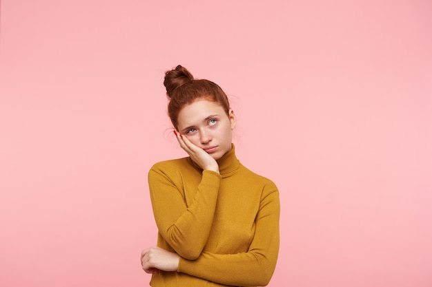 Young pretty redhead female with bun hairstyle isolated