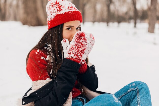 빨간 장갑과 겨울 코트를 입고 니트 모자에 젊은 꽤 웃는 행복 한 여자, 공원에서 산책, 따뜻한 옷에 눈을 가지고 놀고, 손을 따뜻하게