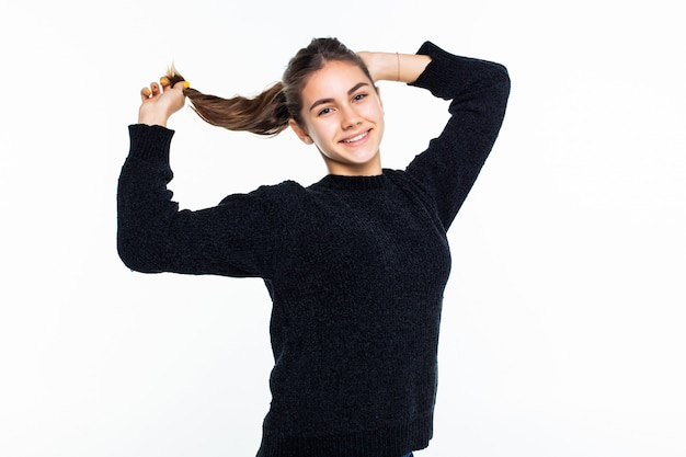 Young pretty teen girl make ponny tail isolated on white wall