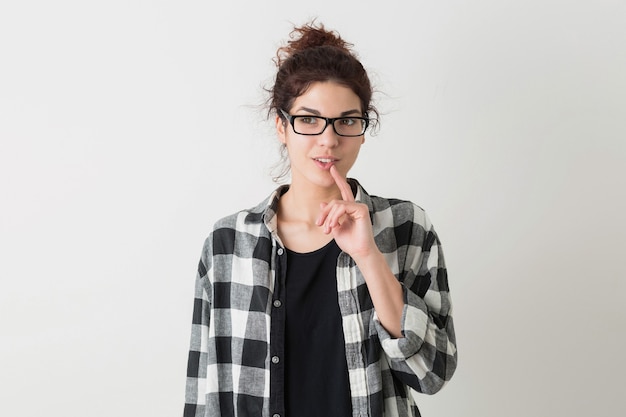 Young pretty woman in glasses thinking, having idea, smiling, happy, sincere emotion, face expression, isolated on white background, checkered shirt, hipster style, student, holding finger at her lips