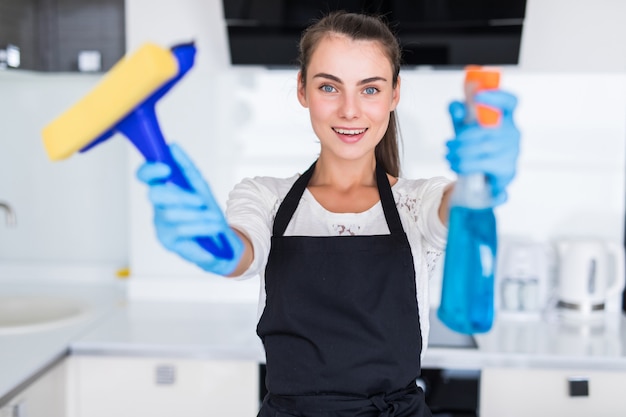 Foto gratuita strumenti puliti hoding della giovane donna graziosa che stanno nella cucina