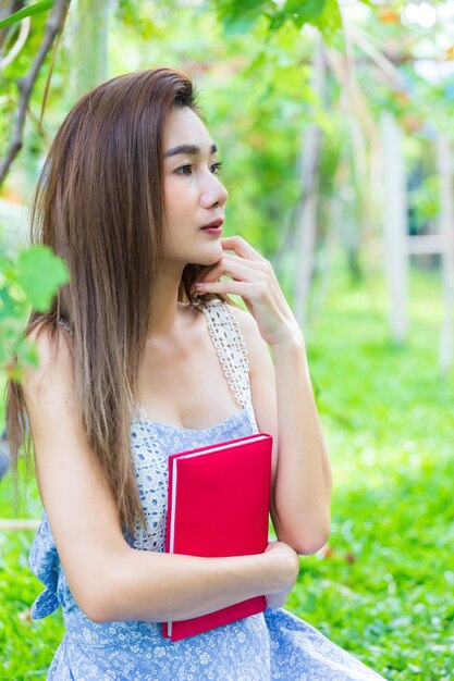 Молодая красивая женщина обнимает дневник в руке