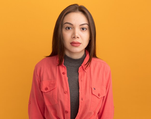 Young pretty woman  isolated on orange wall with copy space